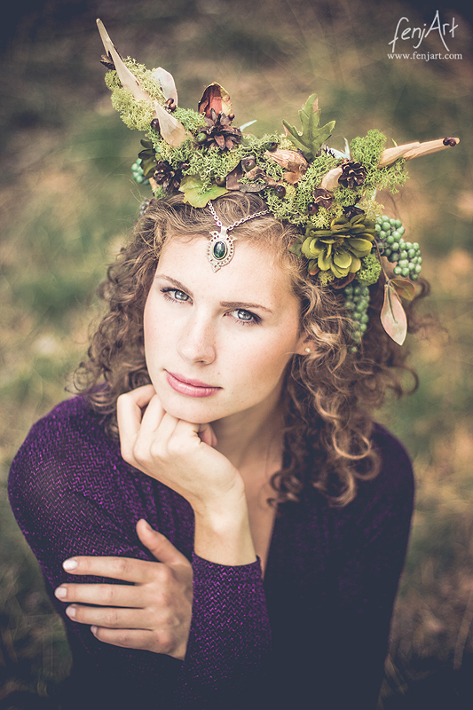 fenjArt Portraitfotografie - braunhaarige frau hockt mit intensivem blick und kopschmuck im wald