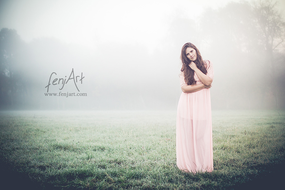 Fotoshooting mit fenjArt Fotografie braunhaarige frau steht in einem langen kleid im morgennebel auf einer wiese in zellhausen